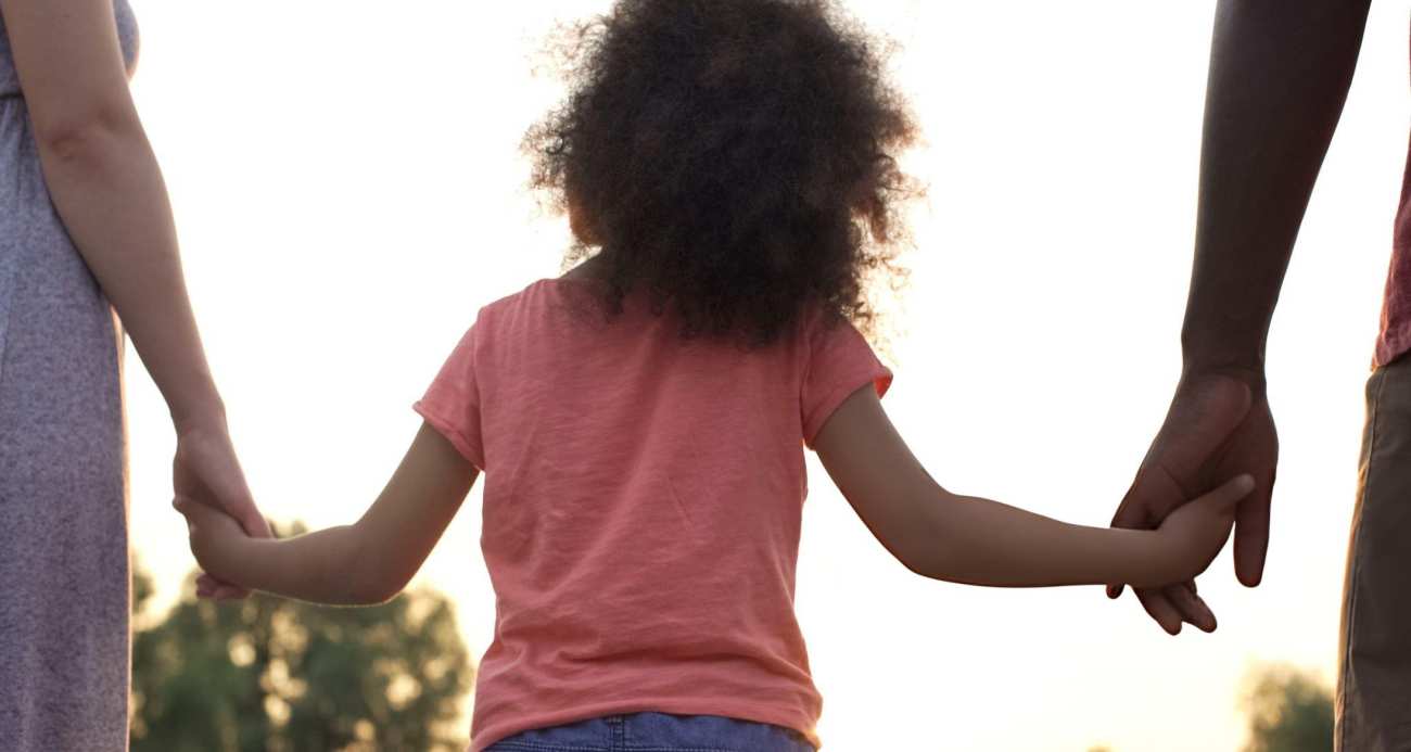 Kid holding hand of parents